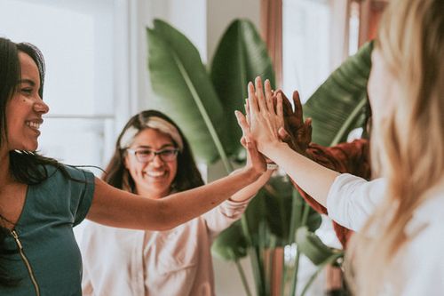 Group of people smiling and joyful having a group high-five